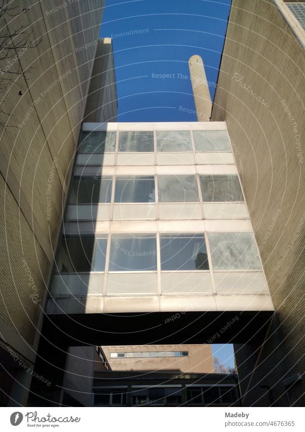 In die Jahre gekommener Neubau der Goethe Universität in Beige und Naturfarben vor blauem Himmel im Sonnenschein im Stadtteil Bockenheim in Frankfurt am Main in Hessen