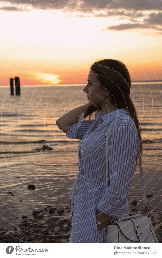 Frau bei Sonnenuntergang am Meer am Strand. Junge Millennial-Frau im Sommer Stil Outfit am Meer. Urlaub Lebensstil am Ferienort. schön im Freien MEER Glück