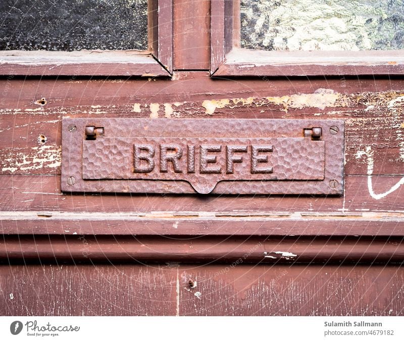 alter Briefschlitz an der Haustür ZEICHEN braun brief briefe briefschlitz schrift symbol typo typografie Briefklappe Post Briefpost Briefeinwurf