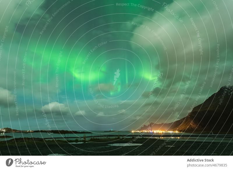 Szenische Meereslandschaft mit felsiger Klippe und Polarlicht in bewölkter Nacht Aurora Natur Berge u. Gebirge Stadt Landschaft Nordlicht polar MEER Strand