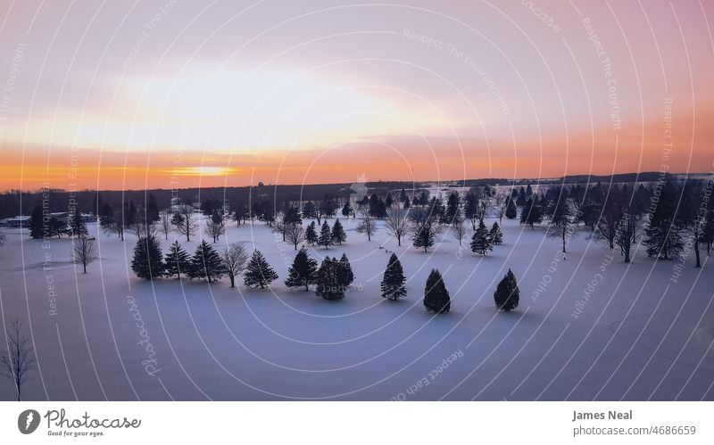 Wintersonnenuntergang über Schneelandschaft Horizont kalt Wolken Landschaft Saison wolkig Morgendämmerung leer Wiese bedeckt Hintergrund Himmel Abenddämmerung