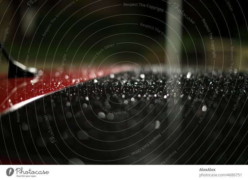 Regennasses PKW- Dach mit Panoramadach und Antenne nachts im Dunkeln Regentropfen regennass rot Dachfenster Panoramafenster Nacht dunkel Autoantenne suburban