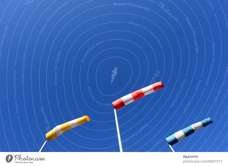 Drei Windsäcke gelb-rot-blau vor strahlend blauem Himmel Windhose Sturm Windrichtung Anzeige Wetter Vorhersage synchron Außenaufnahme gestreift Schönes Wetter