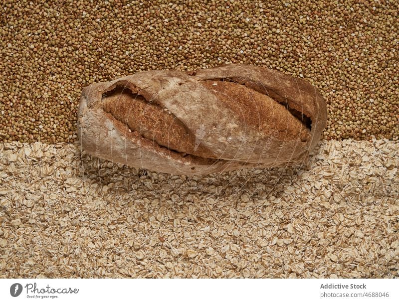 Gebackenes Brot auf rohen Körnern Buchweizen Hafer Korn Bäckerei gebacken Müsli organisch Brotlaib Hintergrund Lebensmittel natürlich ganz Ernährung frisch