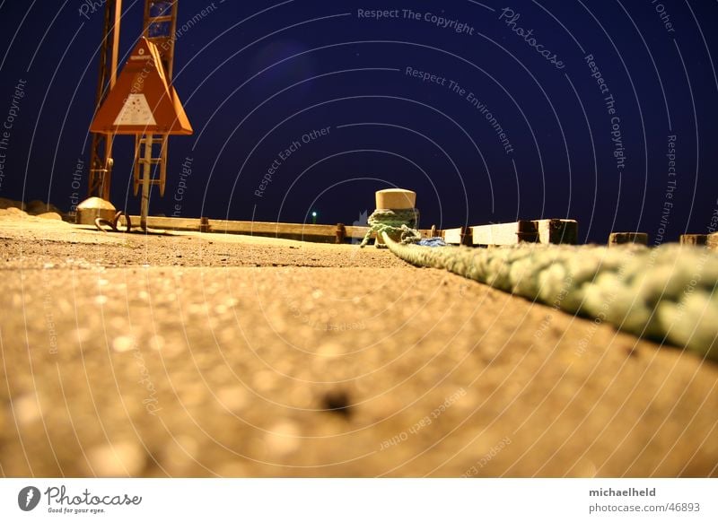 Das zieht sich lange hin Mole Anlegestelle dunkel Nacht Seil Rettungsring Stab Poller Asphalt Beton Froschperspektive Licht Hafen Abend Leiter Strommast