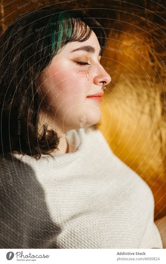 Positive Frau in der Nähe der Mauer an einem sonnigen Tag Wand Sonnenlicht genießen Vorschein verträumt feminin Raum Stil Augen geschlossen