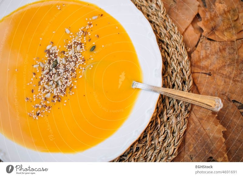 Draufsicht auf Kürbissuppencreme mit einem herbstlichen Hintergrund aus Blättern und Holz abschließen Teller Herbst Farben Koch Kopie Sahne Rahmsuppe cremig