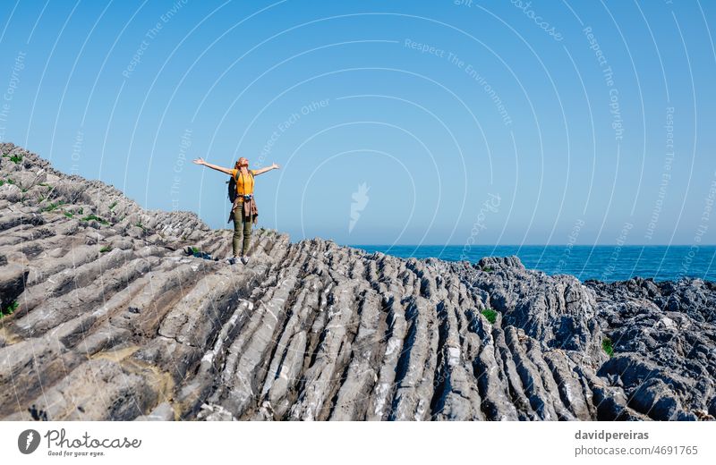 Junge Frau hebt die Arme beim Wandern durch eine Flyschfelsenlandschaft Arme heben Rucksack Textfreiraum Freiheit junger Erwachsener laufen sorgenfrei Trekking