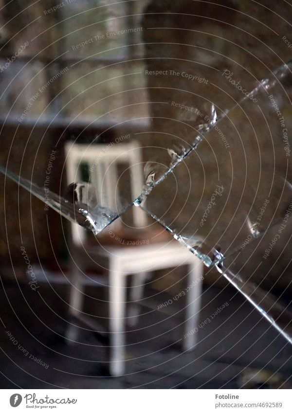 Aufgespießter Stuhl Teil 2. In der restlichen Fensterscheibe spiegelt sich das gegenüber liegende Fenster. lost places alt kaputt Vergänglichkeit Verfall