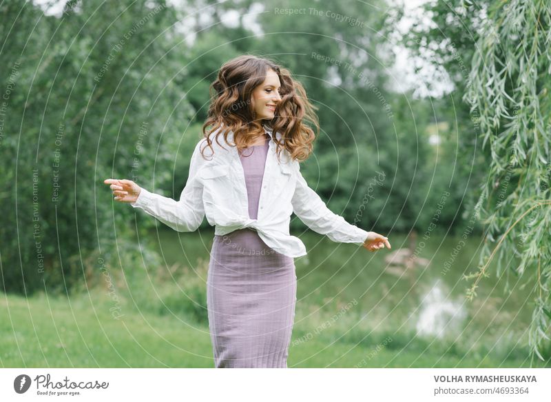 Glückliches Mädchen mit langen gewellten Haaren, die in der Natur im Wind wehen Frau Person Lächeln Gesicht Behaarung Model jung Schönheit Kinder Jugend freudig