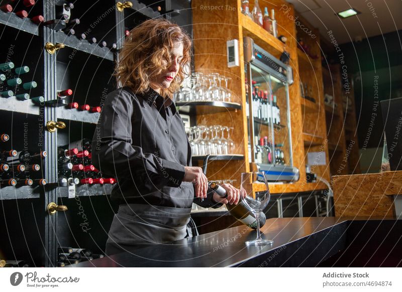 Barkeeper öffnet Weinflasche Flasche offen Alkohol Arbeit Fokus Schnaps Aperitif trinken Weinglas Glas Abfertigungsschalter Schürze Getränk Frau Dienst