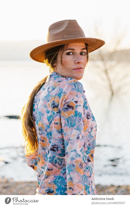 Rätselhafte Frau mit Hut am Strand Stil Wasser Fluss Natur rätselhaft feminin Sommer Landschaft Küste Ufer sensibel Kopfbedeckung Kopfschmuck überbelichtet