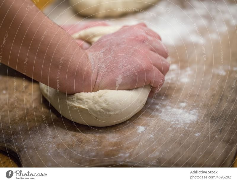 Unbekannter Bäcker knetet Teig in einer Bäckerei Teigwaren Küche kulinarisch Rezept Arbeit kneten roh ungekocht Licht Gastronomie organisch vorbereiten