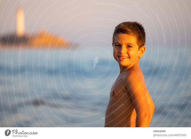 Porträt eines niedlichen Jungen bei Sinset am Strand bezaubernd schön blond blondes Haar Kaukasier Kind Kindheit Konzept Abend Gesicht Familie Spaß lustig