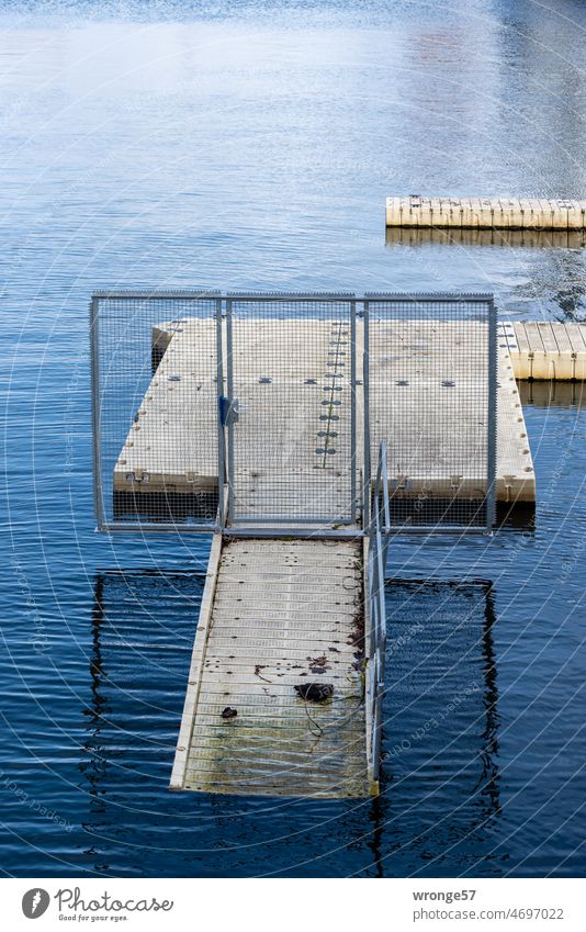 ein leerer Bootssteg wartet auf den Saisonstart Pausenmodus Winterruhe Winterpause Coronapause Hafenbecken Freizeit Wasser Menschenleer Außenaufnahme Farbfoto