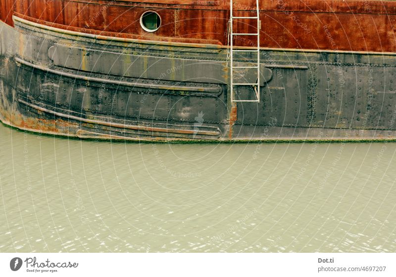 rostiges Schiff Hafenbecken Leiter Bullauge Schiffsrumpf marode Wasserlinie alt Schifffahrt Menschenleer Außenaufnahme maritim Farbfoto Wasserfahrzeug