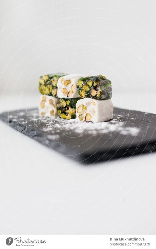 Türkischer Genuss lokum Essen auf Stein Platte Nahaufnahme. Turkish Delight - ein Geleebonbon, typischerweise mit Rosenwasser aromatisiert. Pistazien-Bonbons. Puderzucker Gourmet-Dessert. Kultur traditionelles Essen aus der Türkei.