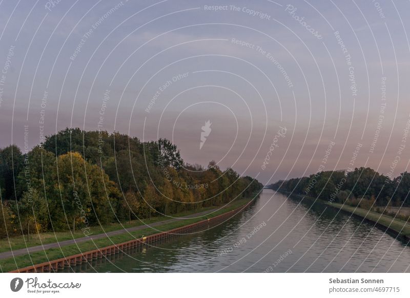 Gerader Wasserkanal in Deutschland Münsterland bei Sonnenuntergang im Herbst Kanal Landschaft Fluss Wasserstraße Natur Hintergrund schön Baum Park im Freien