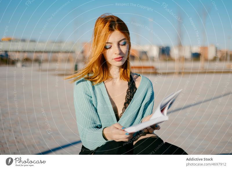 Frau liest Buch auf der Straße lesen Literatur Hobby Zeitvertreib Stil Großstadt Wissen Vorschein charmant Dame anhaben urban Licht feminin Wind fliegendes Haar