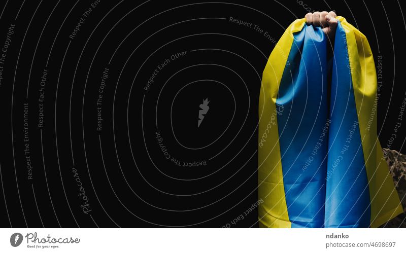 Ein ukrainischer Soldat hält eine Flagge des unabhängigen Staates Ukraine. Standhaftigkeit und Mut des Volkes im Kampf gegen die Invasoren. Der ungebrochene Geist der Nation. Symbol der Unabhängigkeit