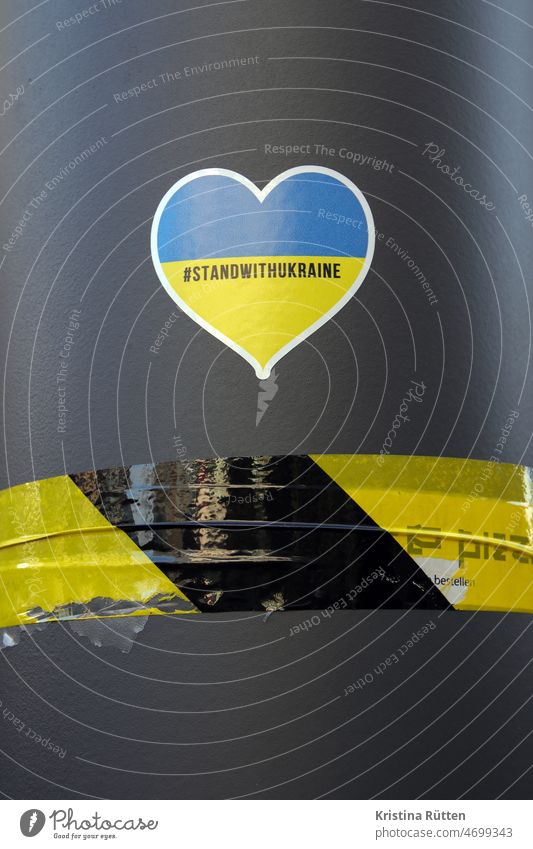 stand with ukraine sticker am laternenpfahl aufkleber frieden solidarität hilfe unterstützung demokratie zeichen symbol botschft draußen öffentlich urban