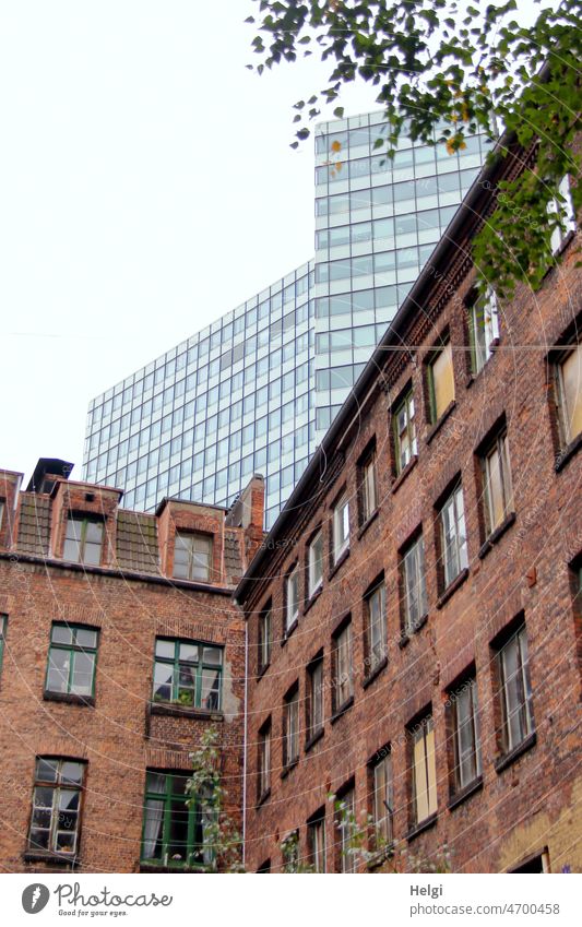 Gegensätze - Fassade eines alten Backsteinhauses, dahinter ein modernes Hochhaus Haus Gebäude Backsteingebäude historisch neu Gegensatz Fenster Altstadt