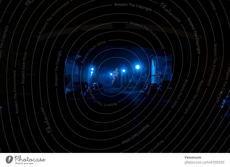 Deutschland,Luckenwalde, 28. Februar 2022,Ein wenig Nebel bei Nacht in einer kleinen Seitenstraße, schönes blaues Licht von den neuen LED-Lampen neblig Straße