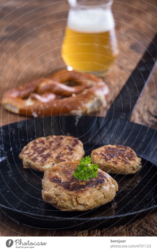 österreichische Kaspressknödel in einer Pfanne Breze Bier lecker Österreich Gericht Kaspressknodel rustikal deftig Küche gekocht Brot Knödel Käse Teller