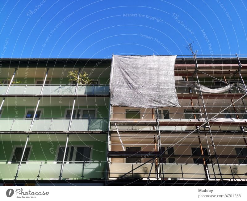 Baugerüst mit Plane an der Fassade zwei Mehrfamilienhäuser im Sommer vor blauem Himmel in Bielefeld im Teutoburger Wald in Ostwestfalen-Lippe Haus Wohnhaus