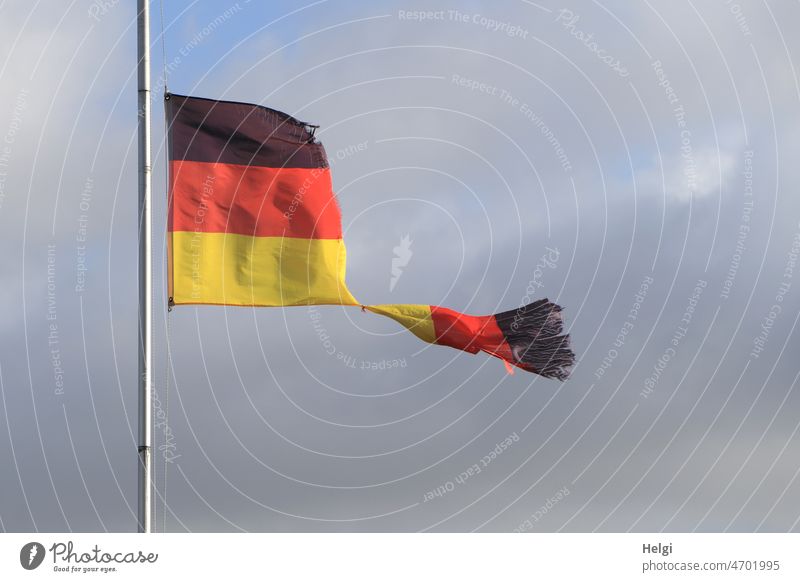 Teekesselchen | Fahne - vom Sturm zerfetzte Deutschlandflagge vor blaugrauem Himmel Flagge schwarz-rot-gold Fahnenstange kaputt Wind stürmisch zerrissen