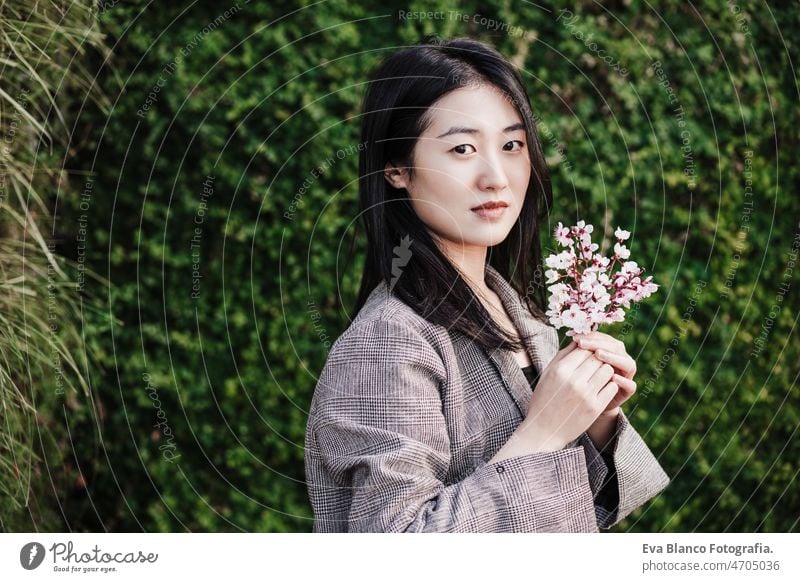 schöne chinesische asiatische Frau hält Mandelbaum Blumen.Frühling. selektiven Fokus auf Blumen Chinesisch Porträt Natur Großstadt Orientalisch jung grün