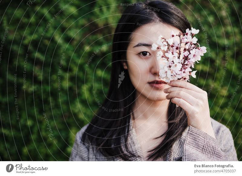 schöne chinesische asiatische Frau hält Mandelbaum Blumen.Frühling. selektiven Fokus auf Blumen Chinesisch Porträt Natur Großstadt Orientalisch jung grün