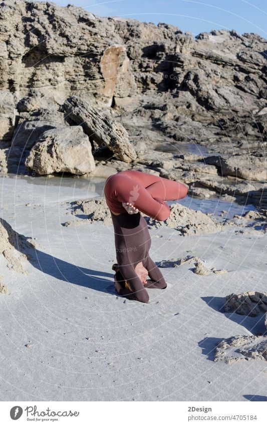 Junge Frau übt Balance-Asanas bei einer Sommer-Yoga-Sitzung an einem schönen Strand auf Formentera, Spanien Person Gleichgewicht Erholung MEER Übung Fitness