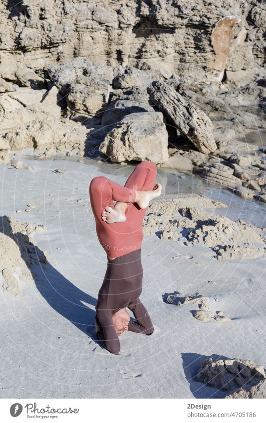 Junge Frau übt Balance-Asanas bei einer Sommer-Yoga-Sitzung an einem schönen Strand auf Formentera, Spanien Person Gleichgewicht Erholung MEER Übung Fitness