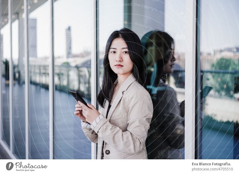 zuversichtlich, schöne chinesische Business-Frau mit Handy im Gebäude Büro. Technik Chinesisch asiatisch Laptop Technik & Technologie Café Kaffee Kantine