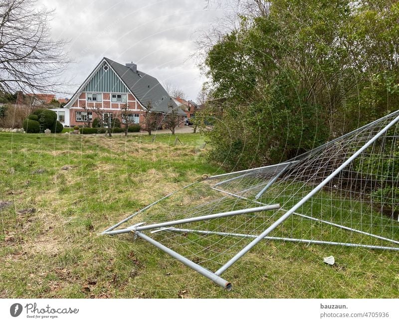 bauzaun hat es umgehauen. Bauzaun Baum Haus Rasen Norddeutschland Landschaft Himmel bewölkt Baustelle Außenaufnahme Menschenleer Farbfoto Zaun Sicherheit