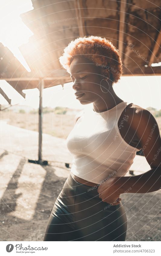 Stilvolle schwarze Frau in der Nähe eines schäbigen Gebäudes trendy Mode Outfit feminin Konstruktion Straße verwittert Bekleidung Vorschein Afroamerikaner