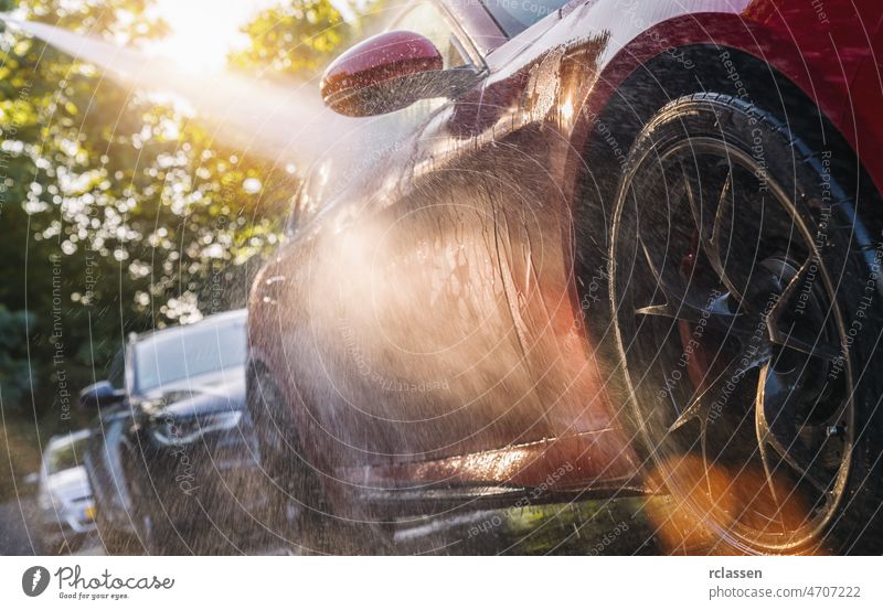 Sommer-Autowäsche. Autowäsche mit Wasserhochdruck. PKW Waschen Druck Waschmaschine suv Sauberkeit Mann Seife Dienst Sonne Pflege rot Business Raumpfleger