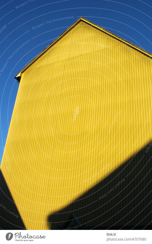 blau gelb Fassade Fassadenverkleidung Wellblech Himmel fensterlos Textfreiraum wolkenlos Hochformat Gebäude Farbfoto Menschenleer Wand Außenaufnahme