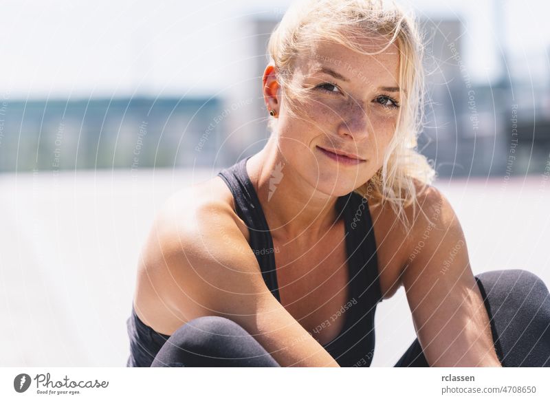 attraktive junge Frau in Sportkleidung, die sich nach dem Training entspannt. Fröhliche Stimmung, wahre Gefühle, gesunder Lebensstil passen Fitnessstudio