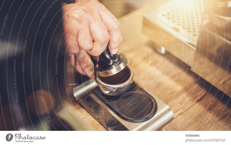 Barista macht Kaffee, drückt vor dem Aufbrühen die Temperatur auf den Filter, im Café Hintergrund Getränk schwarz Business Pulver Portafilter Tasse trinken