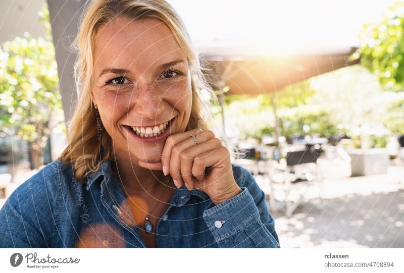 Porträt einer glücklichen reifen Frau, die in die Kamera schaut. Closeup Gesicht der lächelnden Frau sitzt in der Cafeteria mit der Hand auf dem Kinn. Erfolgreiche Frau in einem Cafe-Pub.