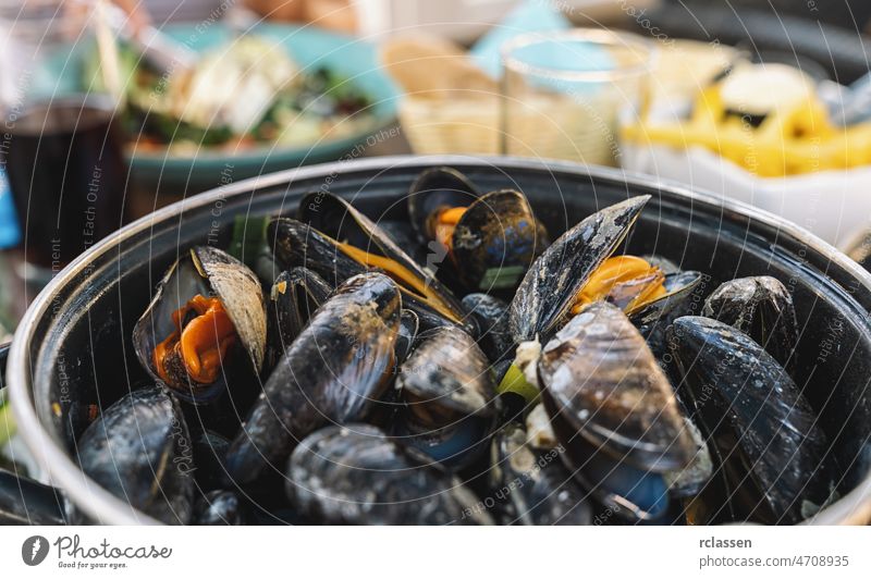 Muscheln in einer Schüssel mit Pommes frites in einem Restaurant.  Ein klassisches Gericht in Belgien, Frankreich und den Niederlanden. Hintergrund