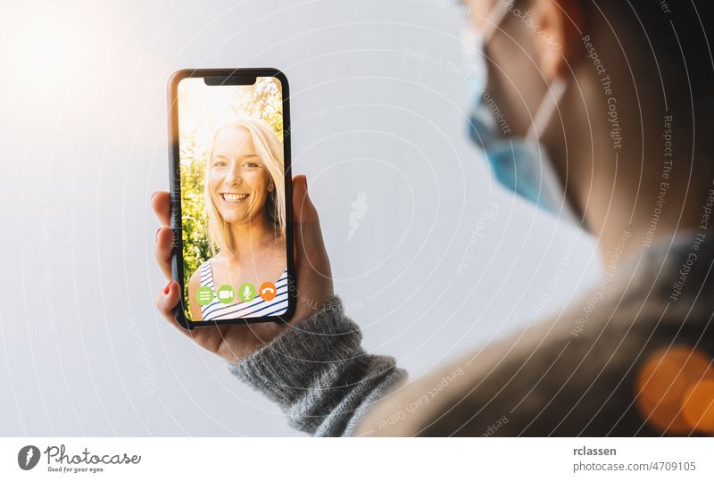 Virtuelles Gespräch mit Freunden, Kollegen und per Videochat-Konferenz. Lernen oder Arbeiten aus der Ferne. Quarantäne zu Hause oder Vorbeugung von Coronavirus-Infektionen (Virus Covid-19). Frau mit Smartphone.
