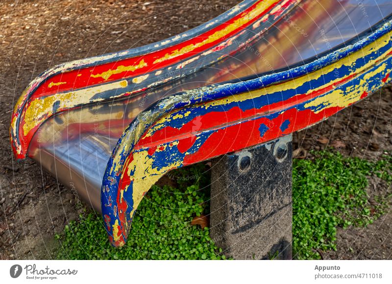 Verwitterte bunte Kinderrutsche (mit Gesicht) Spielzeug Spielplatz Rutsche rutschen spielen toben Kindheit vergangen verwittert rot gelb blau Metall