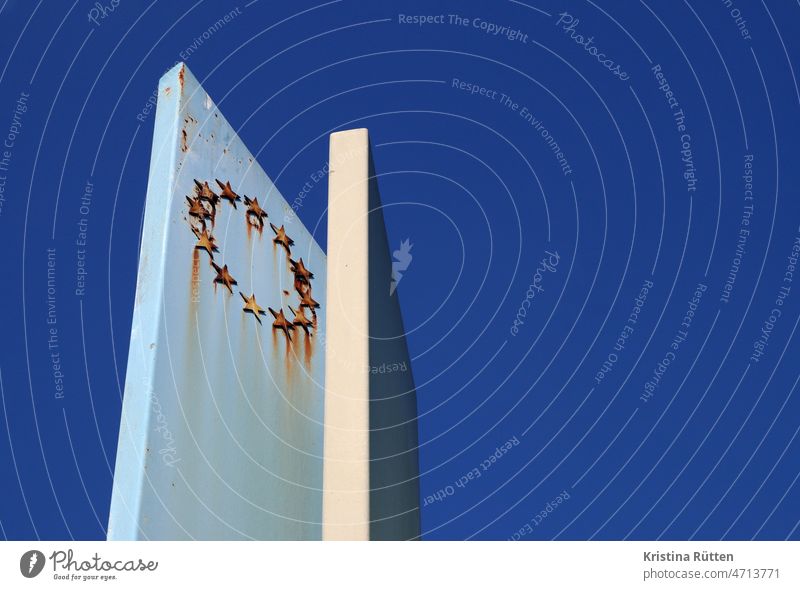 rostiger sternenkranz der europäischen union auf einer stele vor blauem himmel zwölf europa symbol symbolisch europäische gemeinschaft europäische union verbund