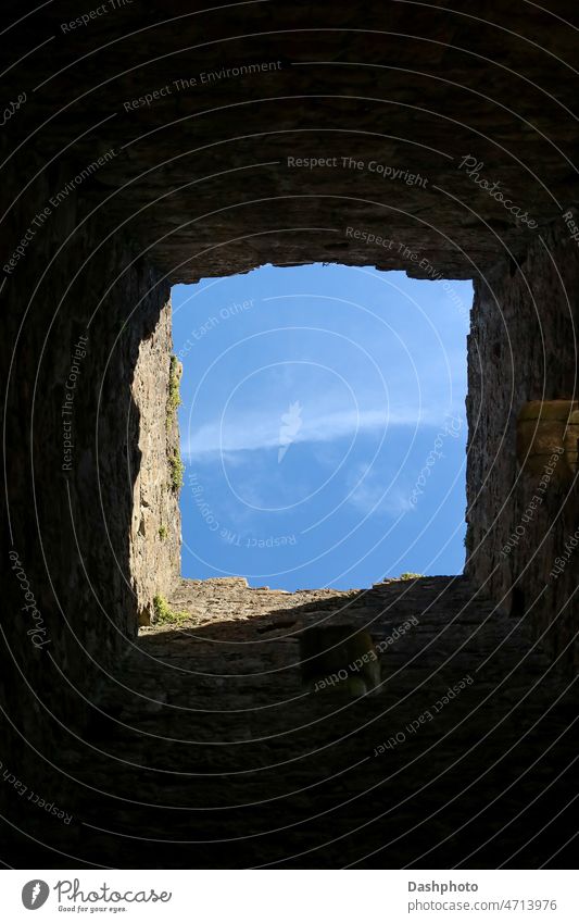 Blick in den Himmel durch ein Fenster in einer alten Burgmauer blau Blauer Himmel Wolken Cloud wolkig Eröffnung Blende Golfloch Lücke Wand Stein Steinwand antik