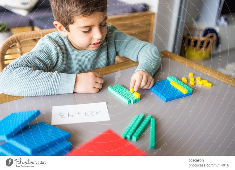 Kleiner Junge, der zu Hause mit der Methode zur Basis 10 addiert Abakus Ergänzung allein Blöcke Kind Kindheit Kinder farbenfroh Konzept Zählen niedlich dezimal