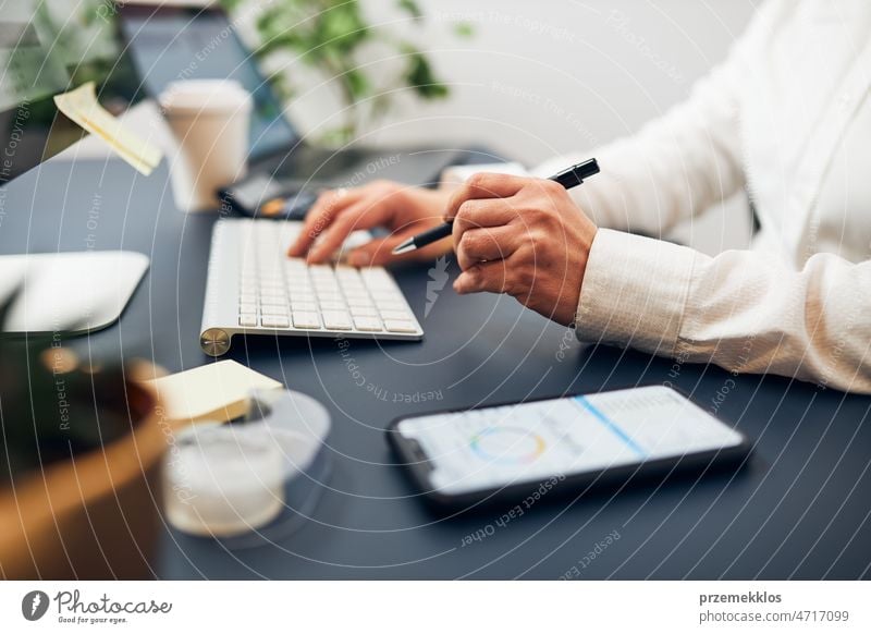 Geschäftsfrau beim Tippen auf der Tastatur. Unternehmerin bei der Arbeit mit Daten auf Diagrammen, Graphen und Diagrammen auf Computer und Smartphone Business