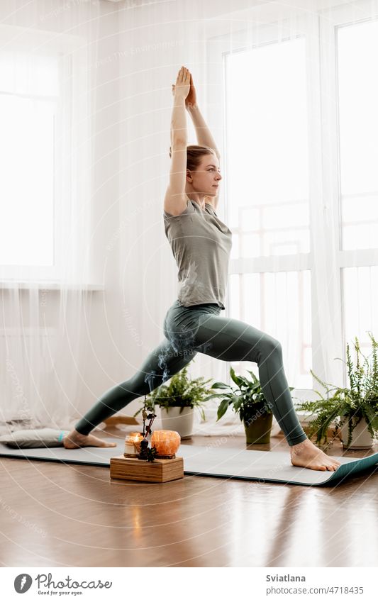 Schöne junge Frau macht Übungen und macht Yoga zu Hause heimwärts praktizieren Körper Lifestyle Fitness Training Meditation Unterlage Sport sportlich